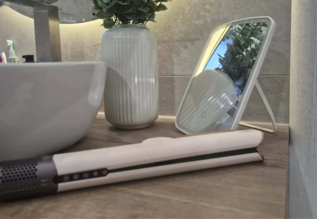 Dyson Airstrait uređaj za ravnanje kose odložen u kupaonici.